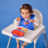 Superman by bbox snackbox lifestyle dziewczynka siedzi w krzesełku do karmienia, na krzesełku leży otwarty snackbox z motywem supermana