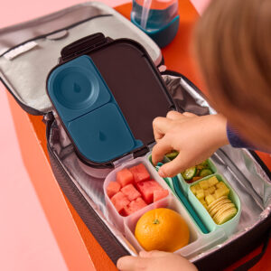 Dziecko sięgające do miętowej wkładki silikonowej w mini lunchboxie b.box spakowanym w torbie termicznej